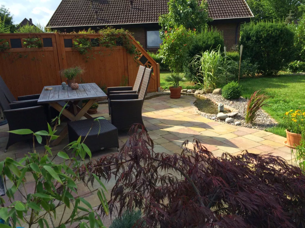 Bachlauf neben einer geschwungenen Holzterrasse