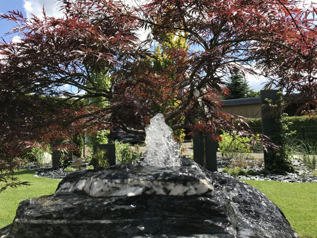 Quellstein als ruhiges Wasserelement im Garten